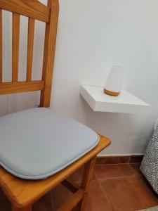 un inodoro blanco sentado en una silla de madera junto a una pared en Casa Natalia., en Taibique