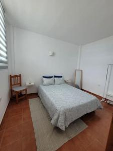 Casa Natalia. في Taibique: غرفة نوم بيضاء بسرير وكرسي