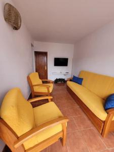 Casa Natalia. في Taibique: غرفة معيشة مع أريكة وكراسي وتلفزيون
