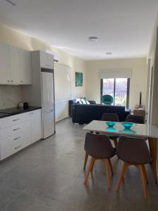 a kitchen and a living room with a table and chairs at Central Two Bedroom Apartment, No 101, by IMH Travel & Tours in Paphos