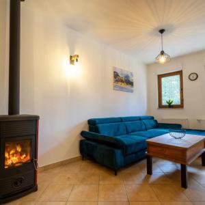 a living room with a blue couch and a fireplace at Apartman Lux Blidinje in Blidinje