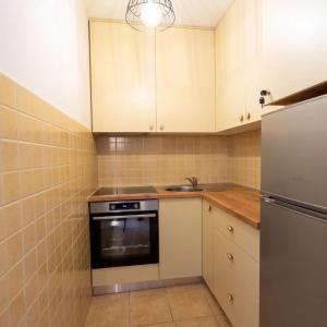 a small kitchen with white cabinets and a refrigerator at Apartman Lux Blidinje in Blidinje