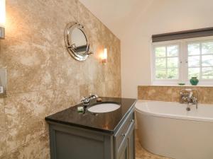 a bathroom with a sink and a bath tub and a mirror at Landmark in Salcombe +38 photos