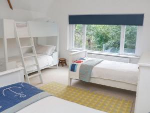 a bedroom with two bunk beds and a window at Landmark in Salcombe