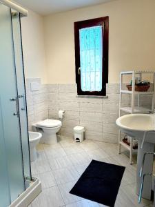 Un baño con inodoro, lavabo y ventana. en Casa Clelia, en Ponte Buggianese 20 fotos más
