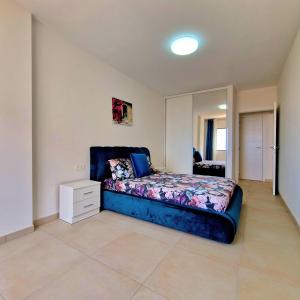 a bedroom with a blue bed and a mirror at Cozy Ocean view 1 BDR APT, Club Paraiso in Playa Paraiso +31 photos
