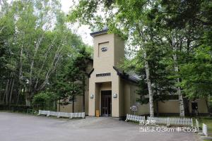 a building with a fence in front of it at カフェロッジ Touch Wood in Biei