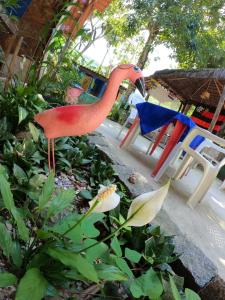 uma estátua de um flamingo ao lado de duas cadeiras em Casarão Hostel e Pousada em Abraão