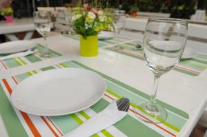 a table with a white plate and glasses on it at Regent Suvarnabhumi Hotel in Lat Krabang