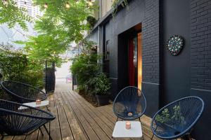 a patio with two blue chairs and tables on a building at Platine Hotel in Paris