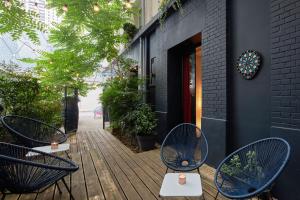 d'une terrasse avec 2 chaises bleues et des tables dans un bâtiment. dans l'établissement Platine Hotel, à Paris