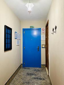 Una puerta azul en una habitación con pasillo en Apartamentos Turísticos Santa Marina, en Aracena