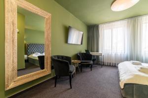 a hotel room with a mirror and a bed at Fullton Central in Cluj-Napoca