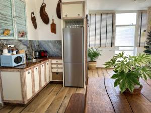 um frigorífico de aço inoxidável numa cozinha com pisos de madeira em הסוויטה הפנורמית - Panoramic Suite em Nurit