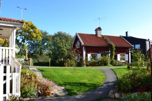 una casa con un camino que conduce a un patio en Stuga med lantlig känsla nära Örebro city en Örebro