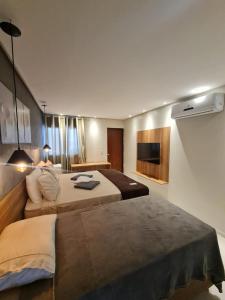 Habitación de hotel con 2 camas y TV en Pousada Maré do Francês en Praia do Frances