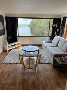 een woonkamer met een bank en een tafel bij C'est la Vie Houseboat in Nederhorst den Berg