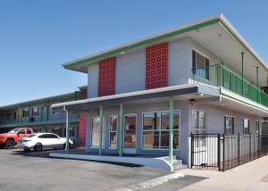 a building with a car parked in a parking lot at GREELEY UNIVERSITY INN/ GREELEY INN in Greeley