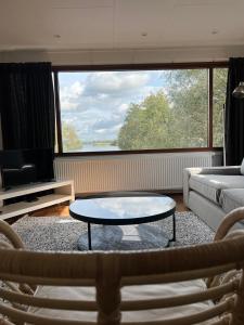 C'est la Vie Houseboat في Nederhorst den Berg: غرفة معيشة مع طاولة قهوة وأريكة