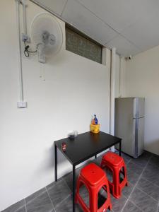 a room with a table and two red stools at 22A HOSTEL in George Town