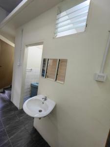 a bathroom with a white sink and a window at 22A HOSTEL in George Town