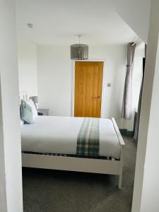 a bedroom with a bed and a wooden door at Lochaline Hotel in Lochaline