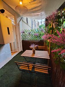 un patio con mesa, bancos y flores en Apartamentos Santander 1, en Santander