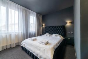 a bedroom with a large bed with white sheets and pillows at Fullton Central in Cluj-Napoca