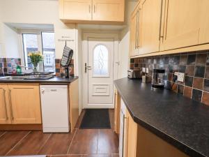 a kitchen with wooden cabinets and a white door at 6 Calgarth View in Windermere