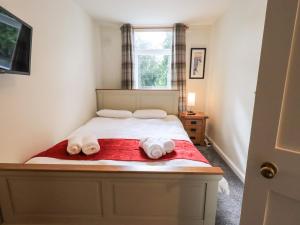 a bedroom with a bed with two towels on it at 6 Calgarth View in Windermere