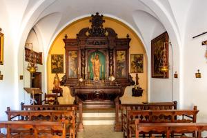 un altar en una iglesia con bancos de madera en NEW Can Blanch 16th Century Masía Pool Chapel, en Argentona