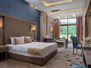فندق منتجع قفقاز توفنداغ مونتاين  في غابالا: غرفة نوم مع سرير مزدوج كبير ومكتب ومكتب