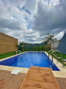 una piscina con terraza de madera y agua azul en Sapanca Havuzlu jakuzili süit Bungalov, en Sapanca