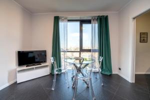 uma sala de estar com uma mesa e uma televisão em 225 - La Corte Luxury Apartment, Centro città con vista panoramica e PARCHEGGIO PRIVATO GRATUITO INCLUSO em Génova