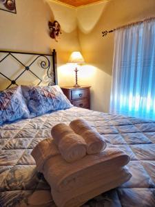 uma cama com uma pilha de toalhas em AL - Casa dos Alentejanos 