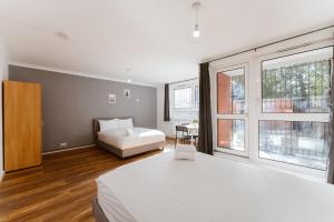 a bedroom with a bed and a large window at Shadwell Double Room - 13 in London