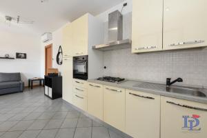eine Küche mit weißen Schränken und einem Waschbecken in der Unterkunft Desenzanoloft Oasis in Desenzano del Garda