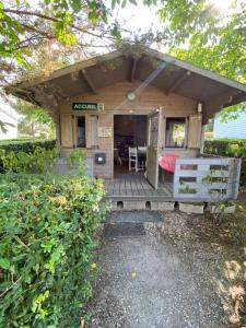 a small cabin with a porch with a table and chairs at Mobil-Home standard in Voyennes
