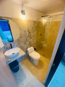 a bathroom with a toilet and a sink and a shower at Hotel el Trebol in Rivera