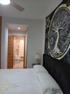 a bedroom with a bed with a tree picture on the wall at HABITACIONES con wifi cerca del Aeropuerto Madrid SUITTE DOBLE con baño privado o Habitacion INDIVIDUAL con baño COMPARTIDO tranquilidad bien comunicadas tren y metro SAN SEBASTIAN DE LOS REYES in San Sebastián de los Reyes