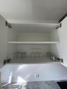 eine Küche mit weißen Regalen und einem Waschbecken in der Unterkunft Rio de Janeiro by estrella24 LIVING ROOMS in Castrop-Rauxel