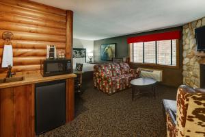 ein Wohnzimmer mit einem Sofa, einem Stuhl und einem TV in der Unterkunft Stoney Creek Inn Quincy in Quincy