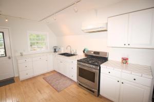 a kitchen with white cabinets and a stove top oven at Mountain Getaway with Lake View in Entriken