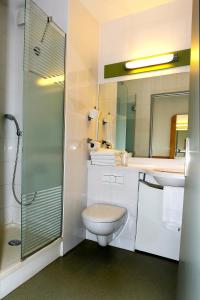 
a bathroom with a shower, toilet and sink at Ibis budget Toulon centre in Toulon
