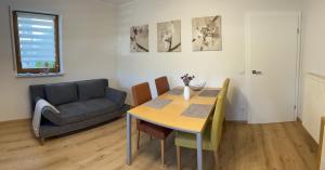 uma sala de estar com uma mesa de jantar e um sofá em Ferienwohnung Nimstal em Rittersdorf