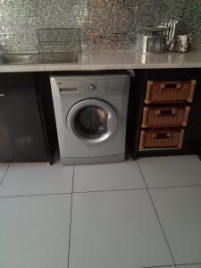 una lavatrice sotto un bancone in cucina di The Executive 5 BnB a Manzini