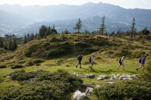 a group of people walking on a grassy hill at Bergwelten Salwideli in Sörenberg