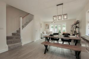 a living room with a dining room table and a staircase at Luxury Colchester House in Colchester