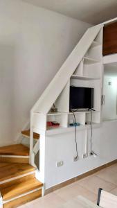 Una escalera blanca con TV debajo. en Encanto Fueguino calido centrico wifi para dos en Ushuaia