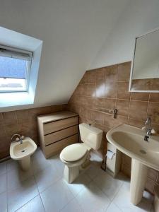 a bathroom with a toilet and a sink at Charmante maison en pierre in Morlaix